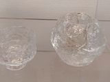 a glass vase and a glass candle holder on display