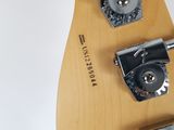 a close up of an electric guitar with a wooden neck