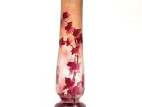a glass vase with red flowers in it on a table