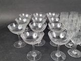 several clear wine glasses are lined up on a black surface