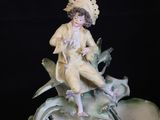 a figurine of a woman sitting on top of a bowl