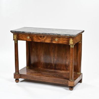 une vieille table en bois avec un plateau en marbre posée sur un plan de travail blanc