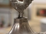 a silver plate with a rooster on top of it