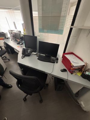 a man sitting at a desk with two computers on it