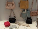 many purses hanging on the wall next to each other