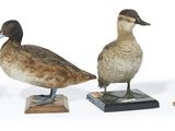 trois canards sont posés sur des socles en bois, sur une surface blanche