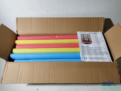 une boîte en carton contenant tout un tas de bâtonnets en mousse de différentes couleurs