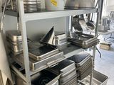 de nombreuses casseroles et ustensiles sur les étagères de la cuisine