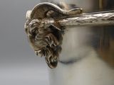 a silver vase with a lion head on the handle