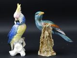 deux figurines d'oiseaux perchés sur une souche d'arbre