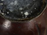 a close up of a brown vase with a white label on it