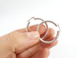 a person holding a pair of hoop earrings in their hand