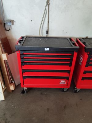 Deux caisses à outils rouges sont posées l'une à côté de l'autre dans un garage.