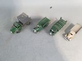 several toy trucks are lined up in a row on a white surface