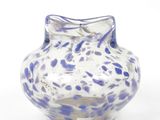 un vase bleu et blanc posé sur une surface blanche