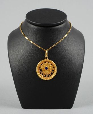 un collier plaqué or, de forme circulaire, orné d'une pierre bleue