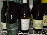 many bottles of wine in the refrigerator on the shelf