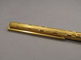 an image of a golden pen on a gray surface