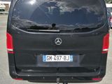 a black van parked in a parking lot with a person taking a picture
