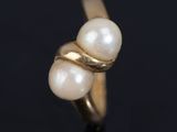 a close up of a gold ring with three pearls on it