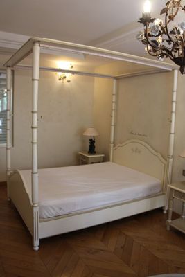 une photo d'une chambre à coucher avec un lit à baldaquin et un lustre