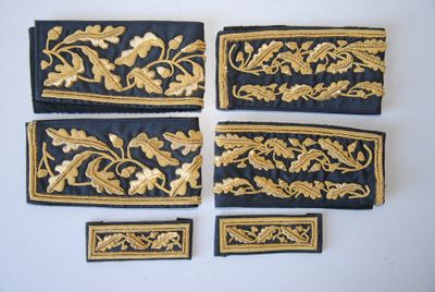 quatre morceaux de tissu brodé noir et or, ornés de motifs en feuille d'or