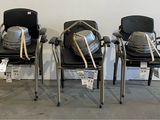 three chairs with backpacks sitting on them in a room
