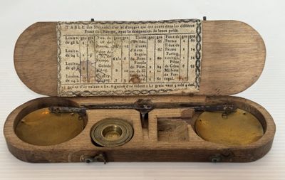 une vieille boîte en bois contenant deux récipients en laiton