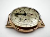 a close up of a gold watch on a white surface