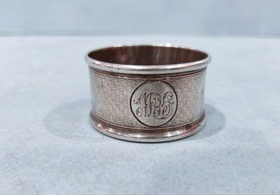 a close up of a silver ring with a monogram on it