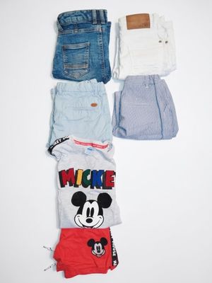 several pairs of shorts and t - shirts laid out on a white surface