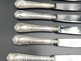 six knives and a knife holder on a table