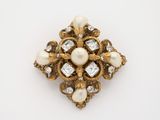 a close up of a brooch with pearls and diamonds