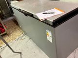 a silver refrigerator with a notepad on top of it