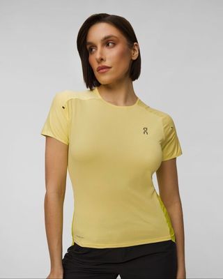 une femme vêtue d'un t-shirt jaune et d'un pantalon noir