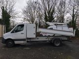 a white truck with a boat on the back of it
