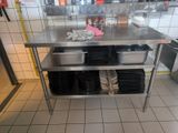 a stainless steel table in a restaurant kitchen with dishes on it