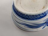 a blue and white cup of coffee on a white table