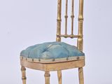 a gold chair with a blue cushion on top of it