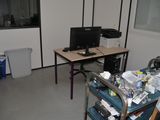 a desk with a computer on top of it in a room
