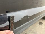 a person measuring the width of a car with a ruler