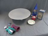 une assiette blanche, une bouteille bleue et d'autres objets posés sur une table