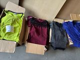 boxes of assorted clothing sitting on the floor in a room