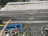 a pile of wood sitting on the ground next to a pile of hoses