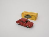 an old red toy car sitting next to a yellow box on a white surface