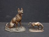two bronze statues of a dog and a horse on a table