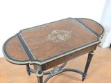a small table with a leather top on a tile floor