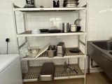 a kitchen with a sink, dish rack, and a washing machine in it