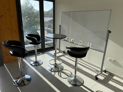 trois chaises et une table dans une pièce dotée d'une paroi vitrée