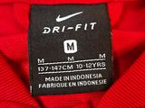 a close up of a red shirt with a black label on it